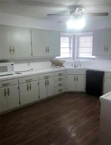 a kitchen with a sink cabinets and wooden floor