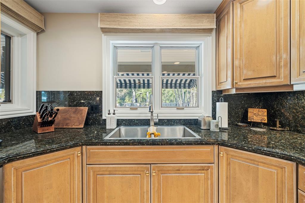 18707 Pepper Pike Lutz, FL 33558 - Photo 13 of 76 a kitchen with granite countertop a sink window and cabinets