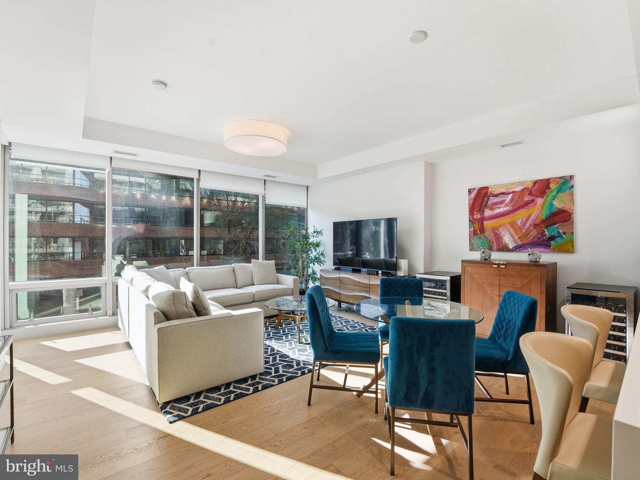a living room with furniture a flat screen tv and a large window