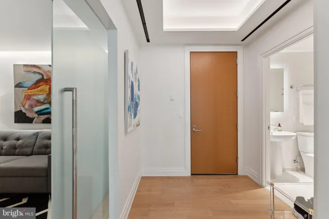 a view of a hallway with wooden floor and furniture