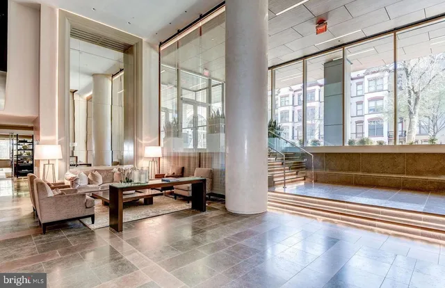 a living room with furniture and floor to ceiling windows