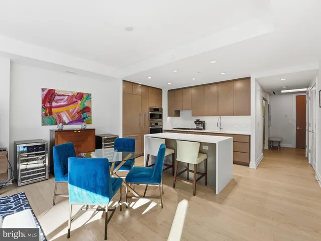 a living room with furniture a flat screen tv and kitchen view