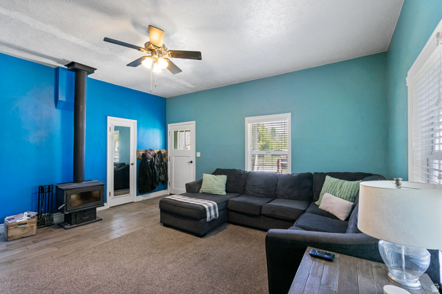 137 West 200 S Street Fairview, UT 84629 - Photo 10 of 34 Living space featuring a wood-burning stove and a ceiling fan with integrated lighting