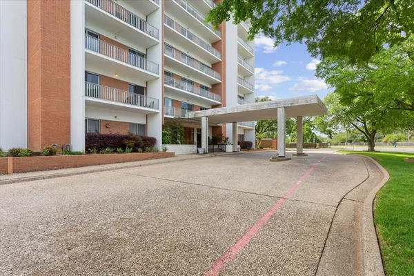 a building with view of street with trees
