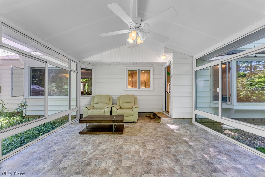 6821 Thornapple Road Gates Mills, OH 44040 - Photo 31 of 42 Enclosed porch featuring a vaulted ceiling with a ceiling fan and light fixture, multiple large windows, a tiled floor, and a white paneled exterior wall