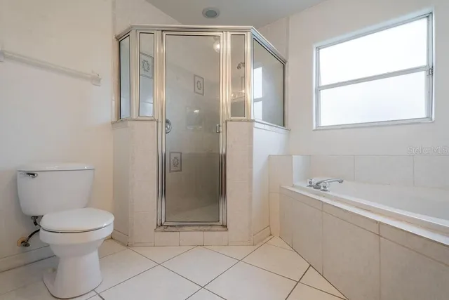 an empty room with windows and ceiling fan