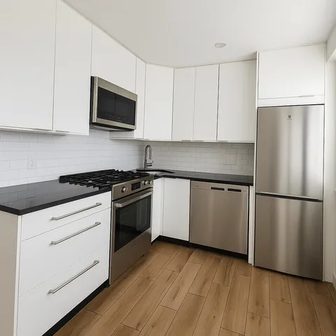 a kitchen with a refrigerator stove and white cabinets
