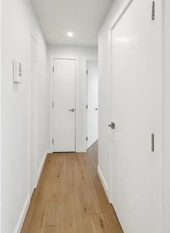 a view of a hallway with wooden floor