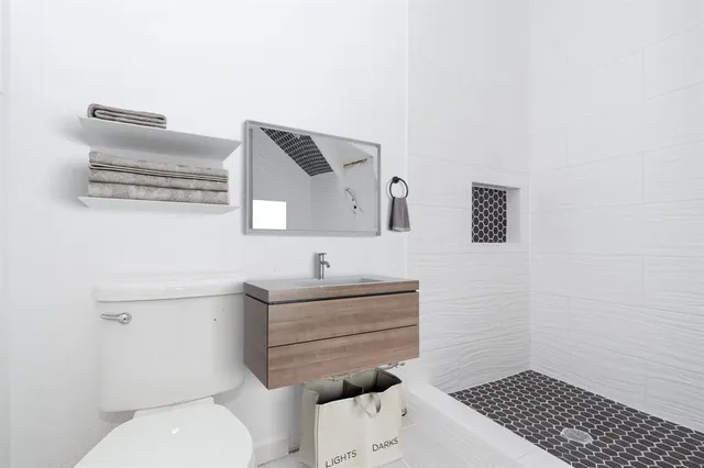 a bathroom with a toilet a sink and mirror