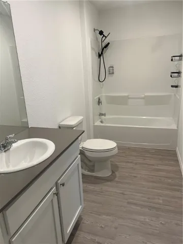 a bathroom with a granite countertop sink toilet a mirror and shower