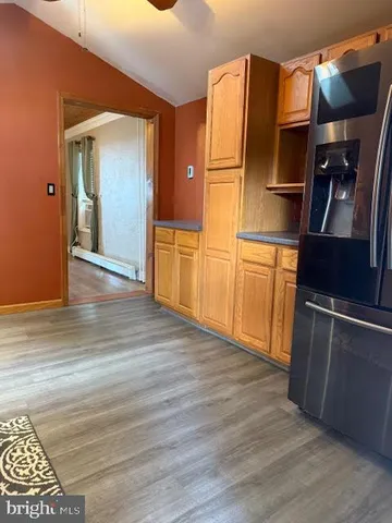 a kitchen with stainless steel appliances wooden floor and chair