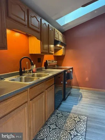 a kitchen with stainless steel appliances granite countertop a sink stove and cabinets