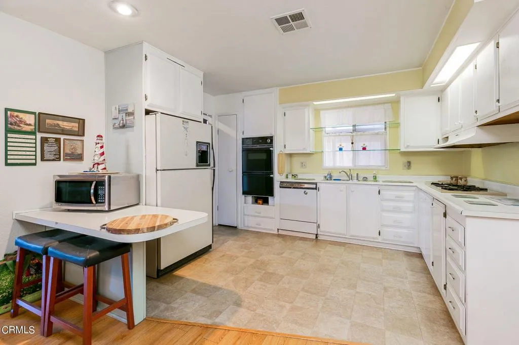 1273 South Rice Road, Unit 100 Ojai, CA 93023 - Photo 11 of 31 a kitchen with stainless steel appliances kitchen island granite countertop a refrigerator and a stove top oven