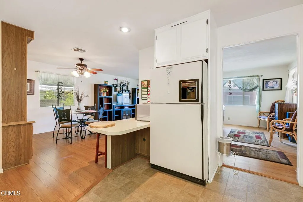 1273 South Rice Road, Unit 100 Ojai, CA 93023 - Photo 10 of 31 a kitchen with stainless steel appliances kitchen island granite countertop a refrigerator a stove a dining table and chairs with wooden floor
