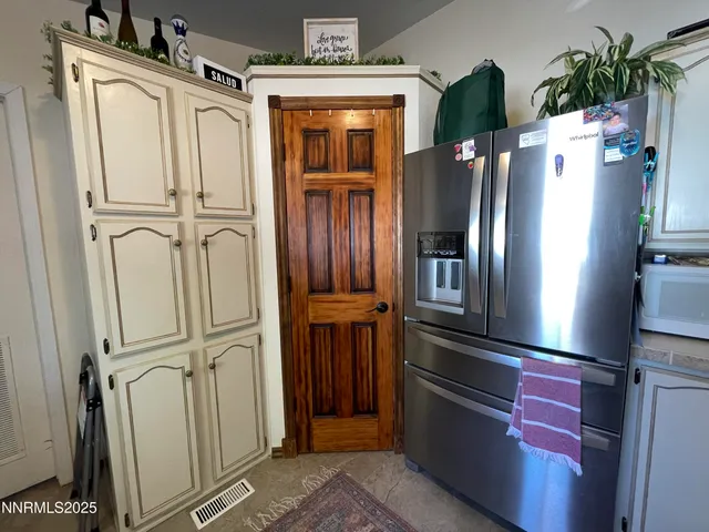 a view of a refrigerator in kitchen and an entryway