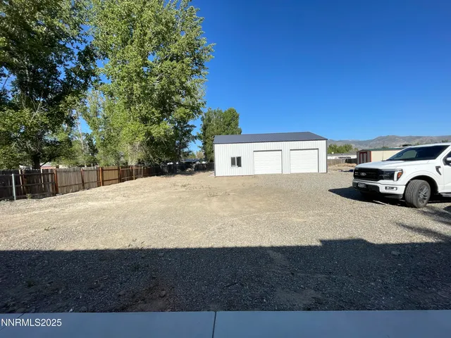 a view of house with yard and car parked