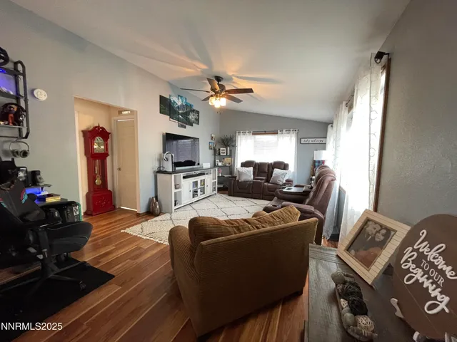 a living room with furniture a flat screen tv and a window