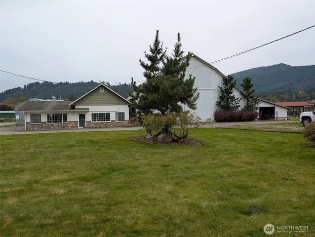 a front view of house with yard and trees in the background