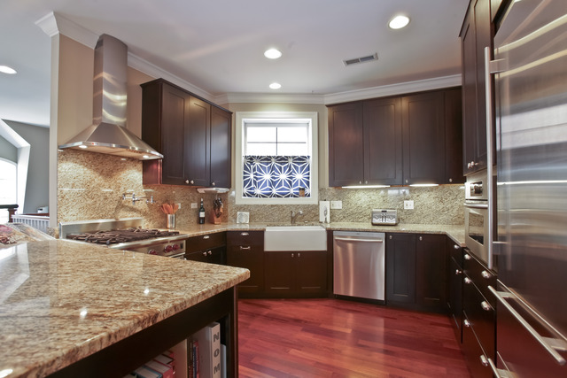 1255 West Addison Street, Unit 3 Chicago, IL 60613 - Photo 4 of 13 a kitchen with stainless steel appliances granite countertop sink stove top oven and cabinets