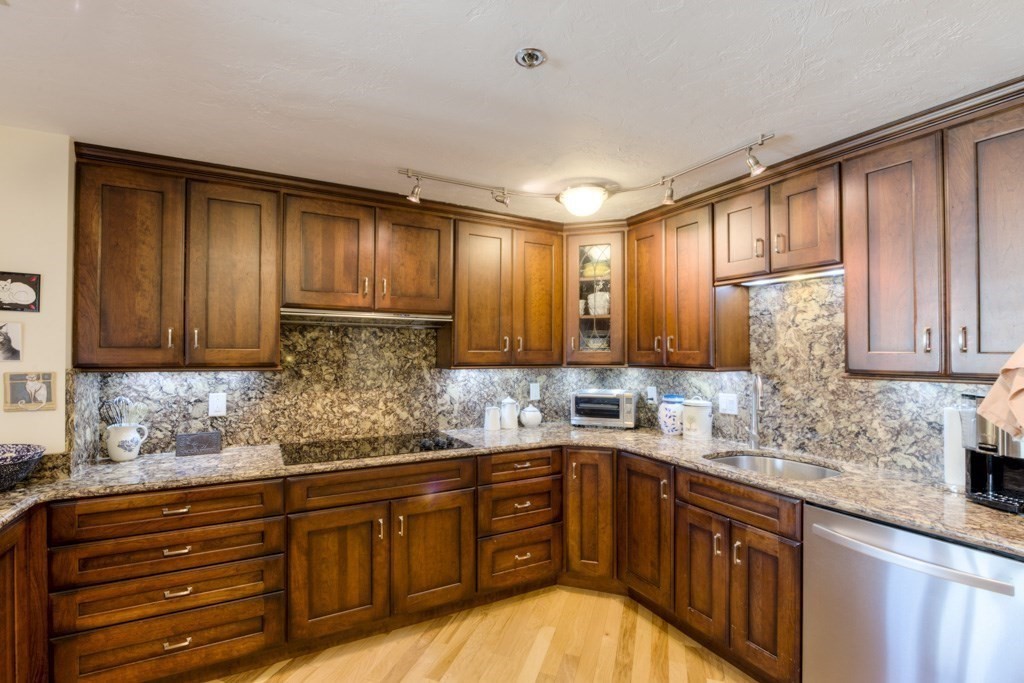 44 Elm Street, Unit 501 Worcester, MA 01609 - Photo 15 of 41 a kitchen with granite countertop wooden cabinets stainless steel appliances a sink and a window