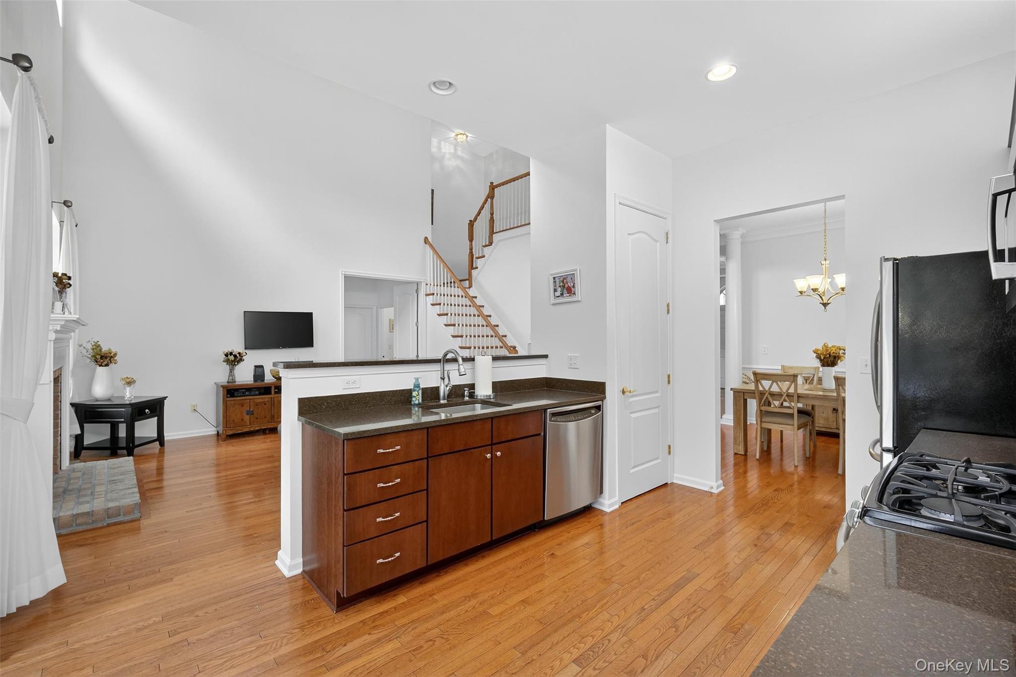 167 Stony Brook Road Fishkill, NY 12524 - Photo 13 of 42 Kitchen with light wood-style flooring, appliances with stainless steel finishes, a peninsula, a fireplace with raised hearth, and recessed lighting