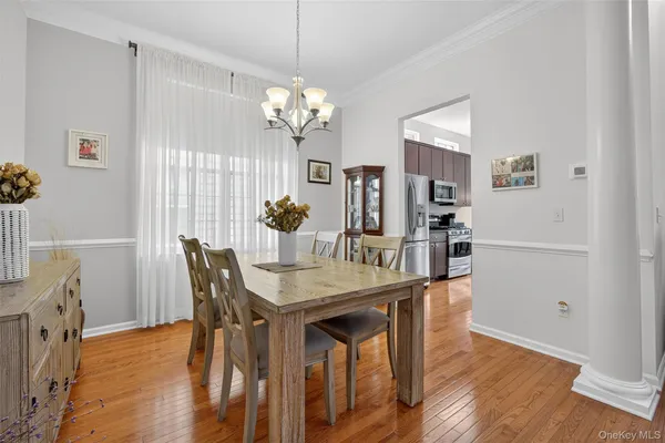 a view of a dining room with furniture a chandelier and wooden floor