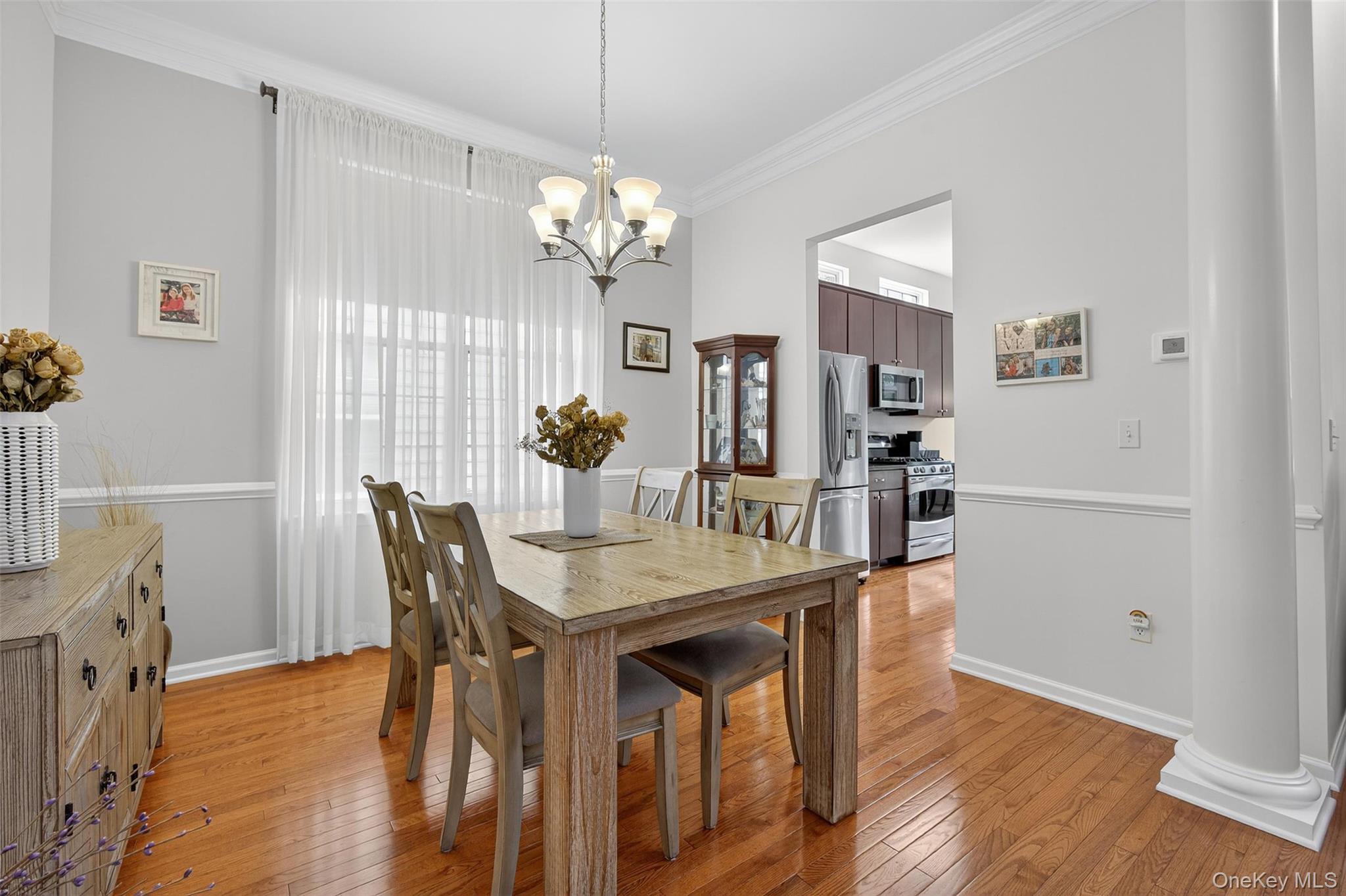 167 Stony Brook Road Fishkill, NY 12524 - Photo 6 of 42 Dining area with light wood-type flooring, ornamental molding, a chandelier, and ornate columns