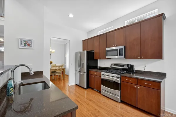 a kitchen with stainless steel appliances granite countertop a stove a sink and a microwave