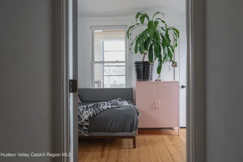 a view of a bedroom with a bed and a window