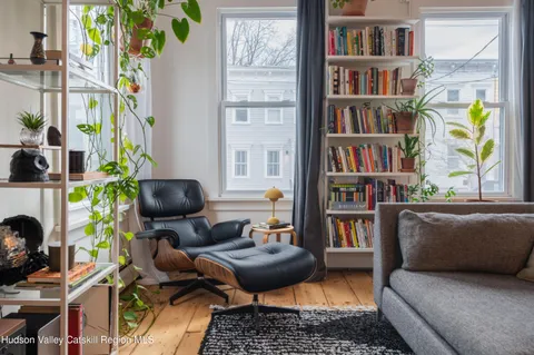 a living room with furniture and a book shelf