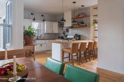 a kitchen with granite countertop a table chairs stove and cabinets