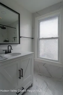 a bedroom with a bed window and potted plant on the wall