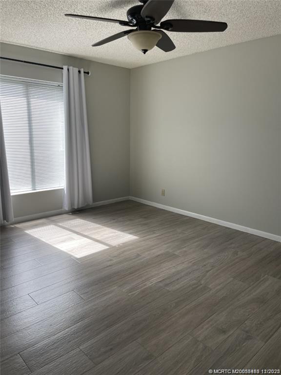2114 Southwest Silver Pine Way, Unit 121F1 Palm City, FL 34990 - Photo 5 of 13 an empty room with wooden floor cabinet and windows