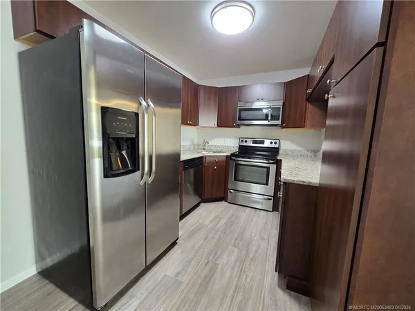 a kitchen with stainless steel appliances granite countertop a refrigerator and a sink