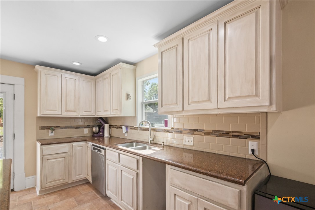 612 Wilbern Street Runge, TX 78151 - Photo 12 of 33 a kitchen with granite countertop white cabinets and white appliances