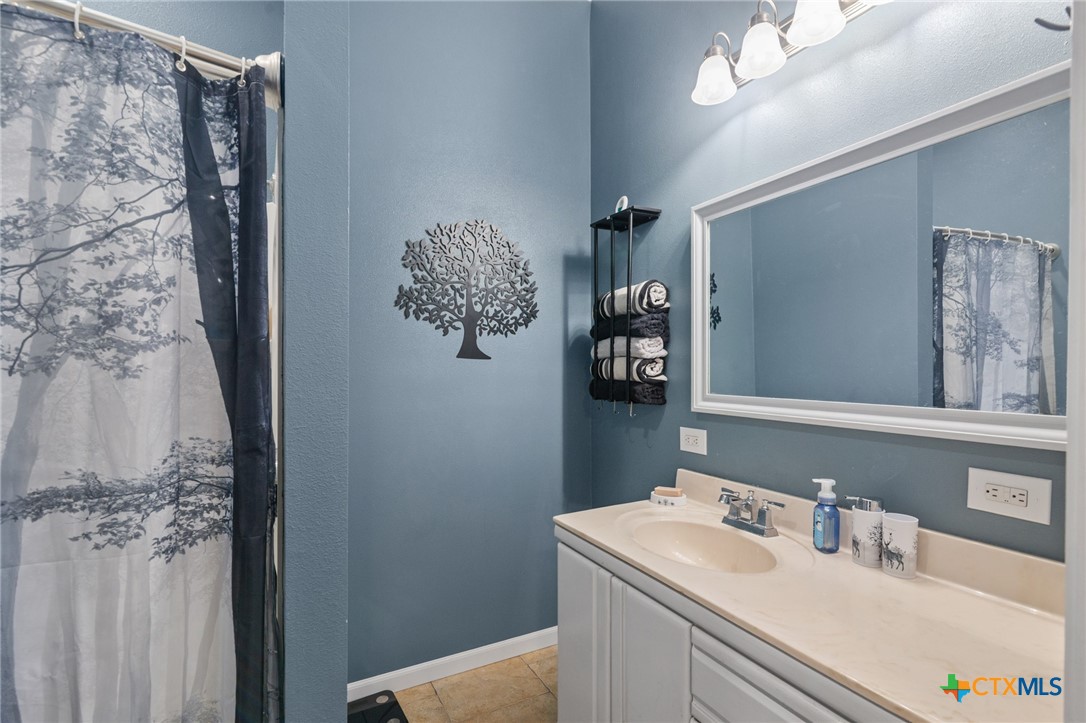 612 Wilbern Street Runge, TX 78151 - Photo 21 of 33 a bathroom with a sink vanity and a mirror