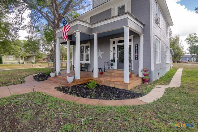 a front view of a house with a yard and trees