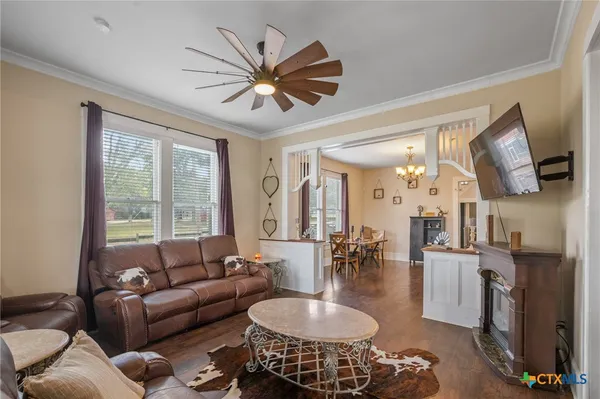 a living room with furniture a flat screen tv and a large window