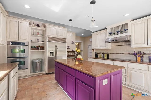 a kitchen with stainless steel appliances granite countertop a refrigerator and a sink