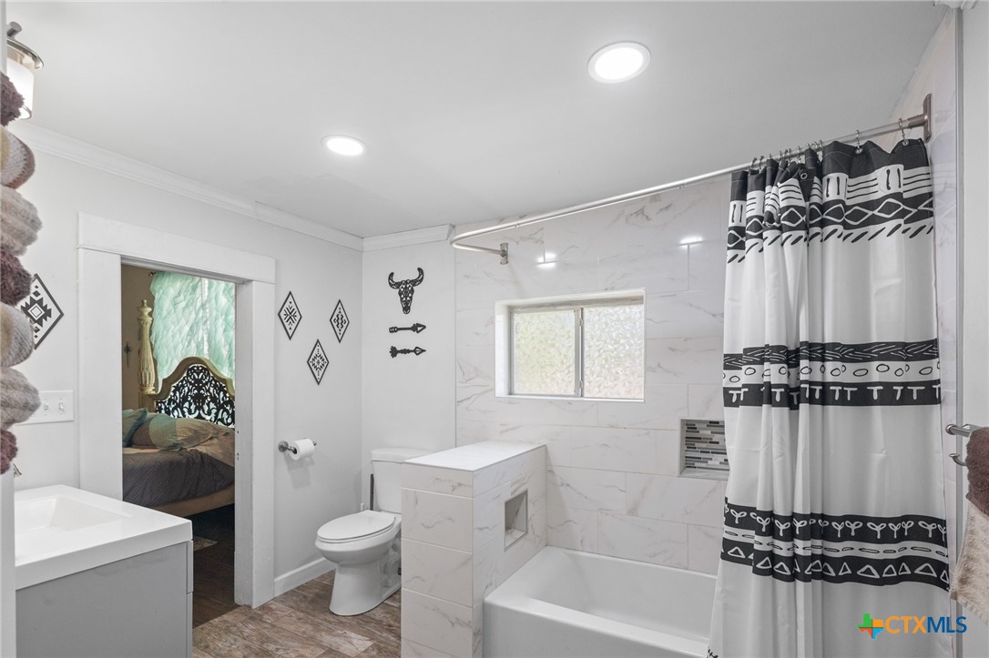 612 Wilbern Street Runge, TX 78151 - Photo 5 of 33 a bathroom with a toilet a sink and a bathtub