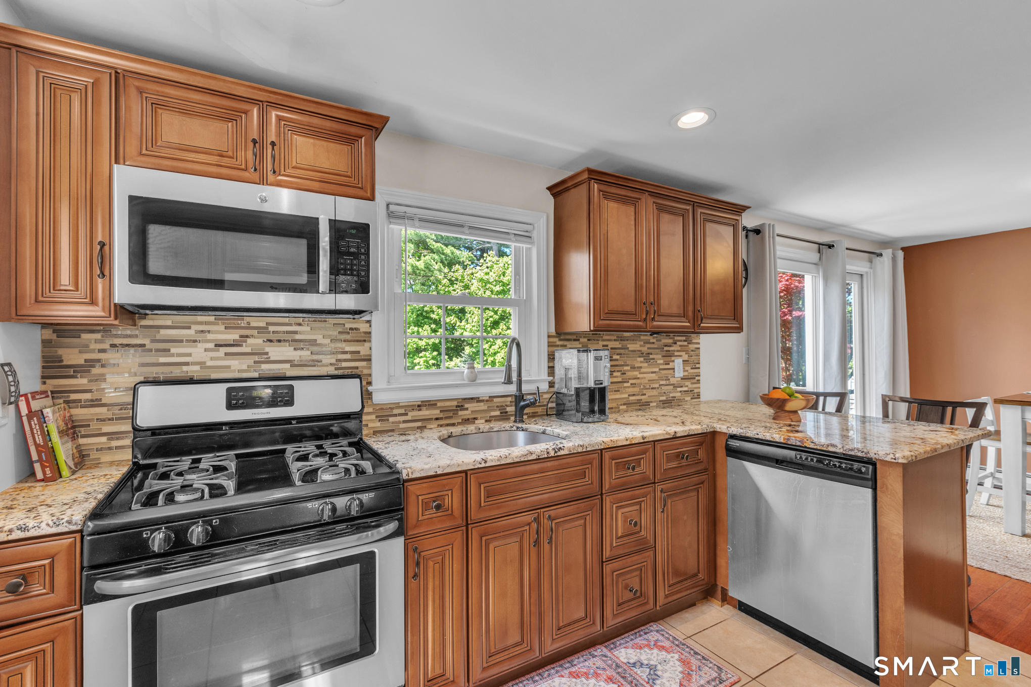 597 Wolcott Hill Road Wethersfield, CT 06109 - Photo 21 of 35 a kitchen with stainless steel appliances a stove sink microwave and cabinets