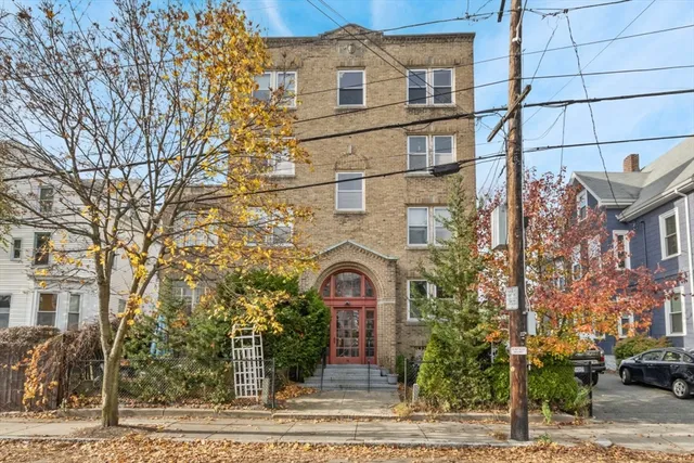 front view of a brick house with a yard