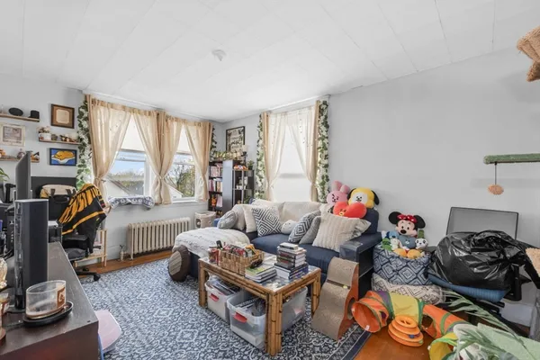 a living room with furniture a flat screen tv and a window