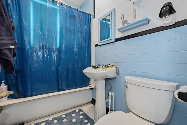 a bathroom with a toilet sink and mirror