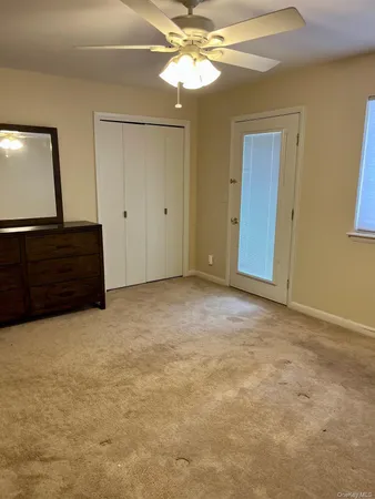 a view of an empty room with window and cabinet