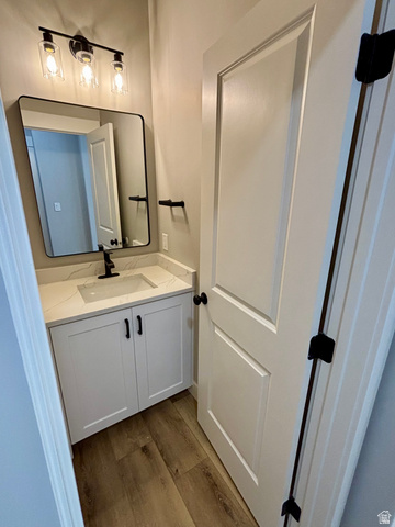 1184 West 3250 North Ogden, UT 84414 - Photo 18 of 69 Contemporary bathroom featuring a white vanity with shaker-style cabinetry, a quartz countertop with an integrated sink, and lvp wood style flooring