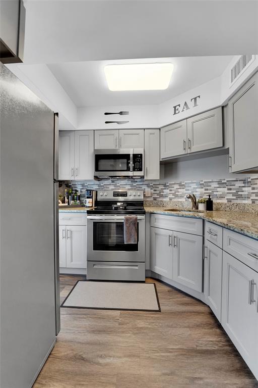 2161 Northeast 42nd Court, Unit 215 Lighthouse Point, FL 33064 - Photo 19 of 50 a kitchen with granite countertop a stove top oven and cabinets