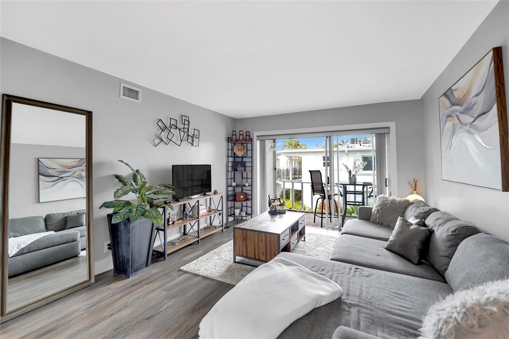 2161 Northeast 42nd Court, Unit 215 Lighthouse Point, FL 33064 - Photo 2 of 50 a living room with furniture and a flat screen tv