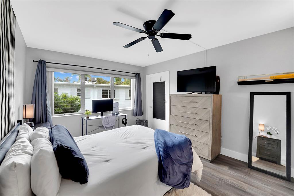 2161 Northeast 42nd Court, Unit 215 Lighthouse Point, FL 33064 - Photo 21 of 50 a bedroom with a bed a flat screen tv and a couch