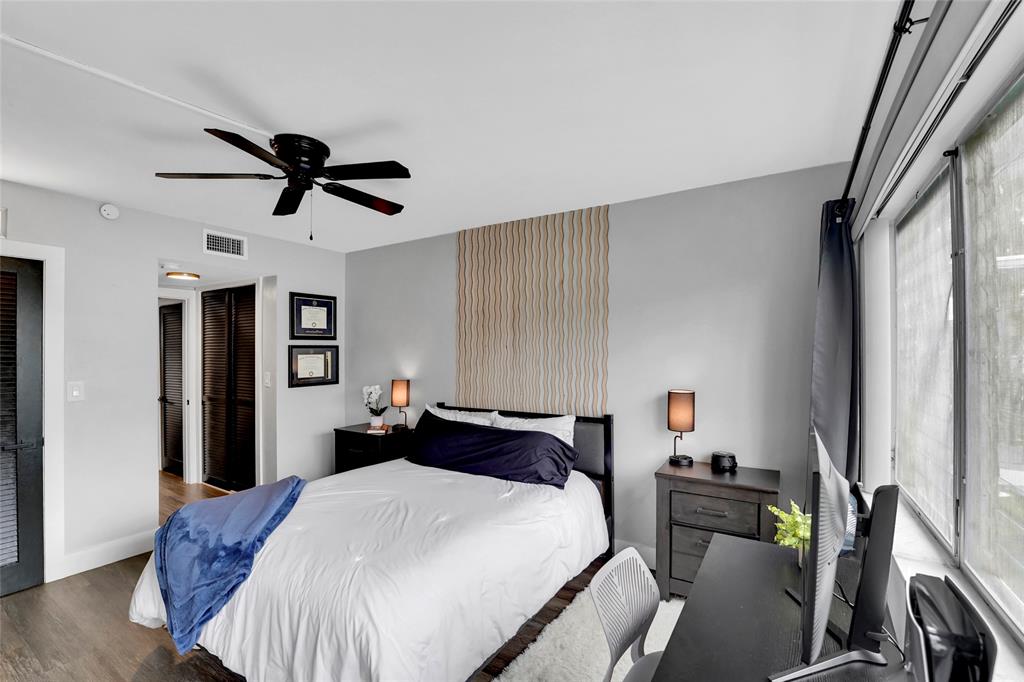 2161 Northeast 42nd Court, Unit 215 Lighthouse Point, FL 33064 - Photo 22 of 50 a bedroom with a bed and a chandelier